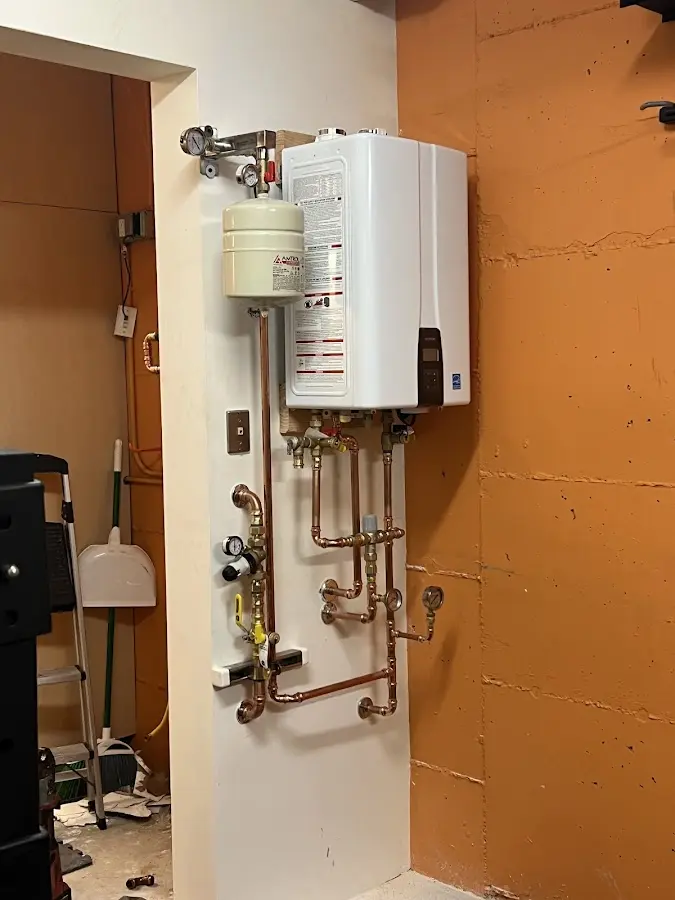 Plumbing technician inspecting water heater connections in Republic
